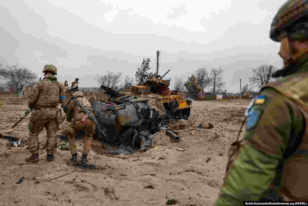 Украинские военные 10-й отдельной горно-штурмовой бригады &quot;Эдельвейс&quot; осматривают уничтоженный российский бронетранспортер БТР-82 в деревне Тетеревское у линии фронта, март 2022 года / Справа фото, сделанное в марте 2024 года. На месте БТР осталась только воронка в песке, уничтоженную технику давно вывезли