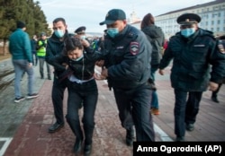 Силовики задерживают участницу акции протеста в Барнауле. Фото: AP