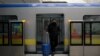 Beijing, China - A man wearing a face mask walks out of the subway with a suitcase in the morning after the extended Lunar New Year holiday caused by the novel coronavirus outbreak, at the Xierqi subway station